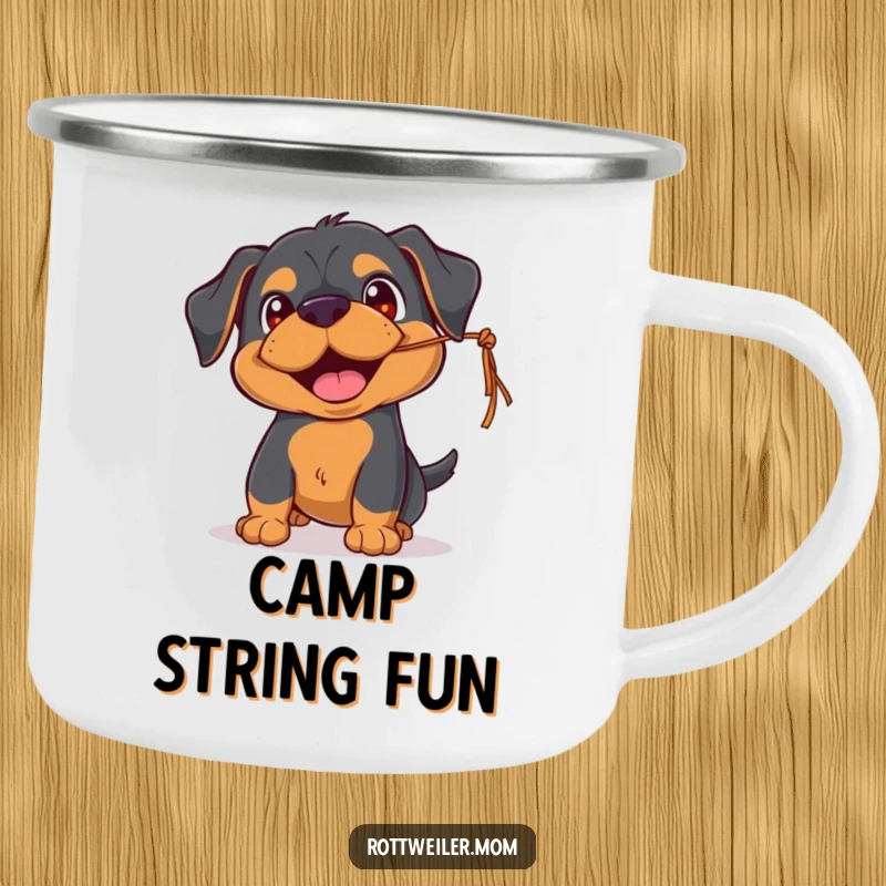 Funny Rottweiler camping mug featuring a playful pup with happy eyes, batting at a dangling string, perfect for outdoor fun.