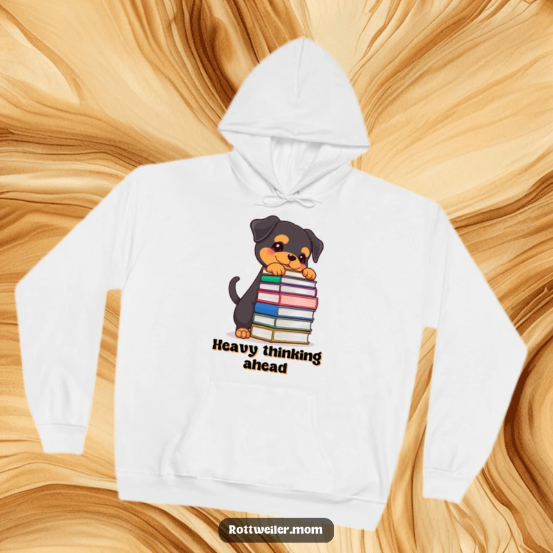 Funny Rottweiler hoodie showing a determined dog with a wagging tail, balancing a large stack of books, perfect for a cozy study session.