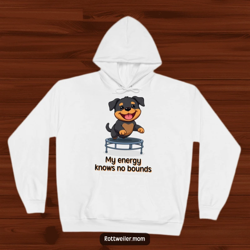 Funny Rottweiler puppy mid-bounce on a trampoline, sporting a massive grin on this comfortable hoodie.